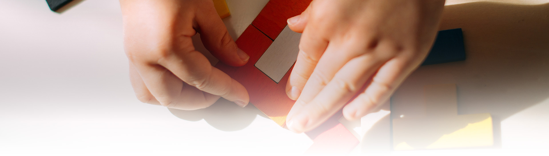 The child creates a figure from a colored puzzle on the table.